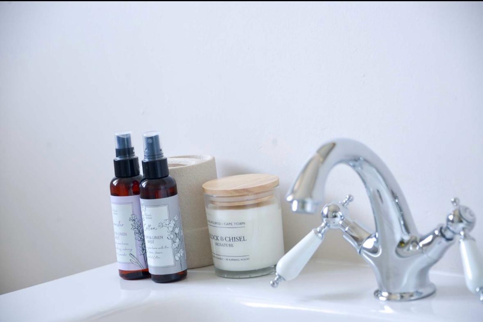 Bathroom details: linen mist, candle and basin tap