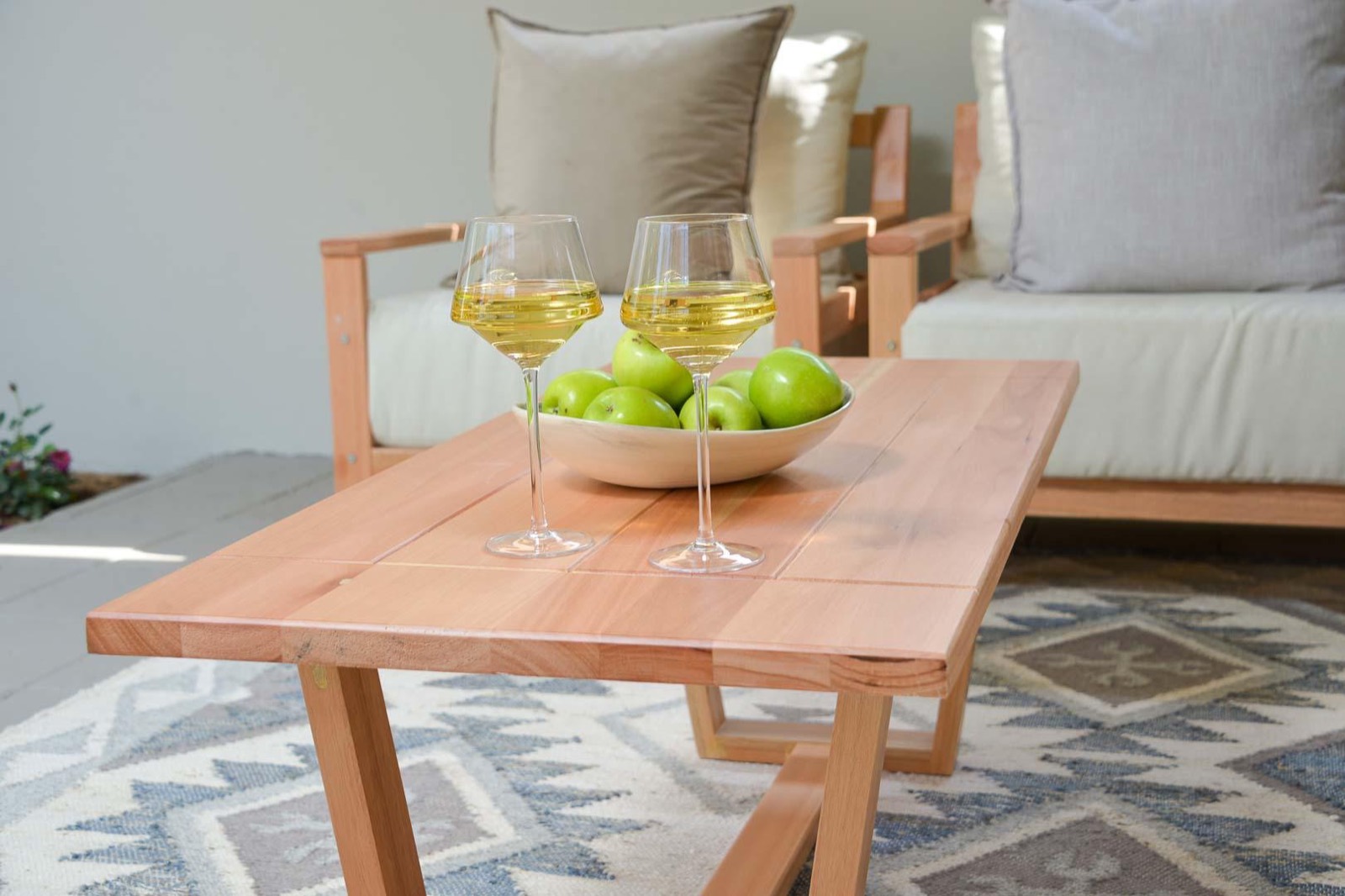 Cushioned teak seating and a coffee table on the shaded garden patio