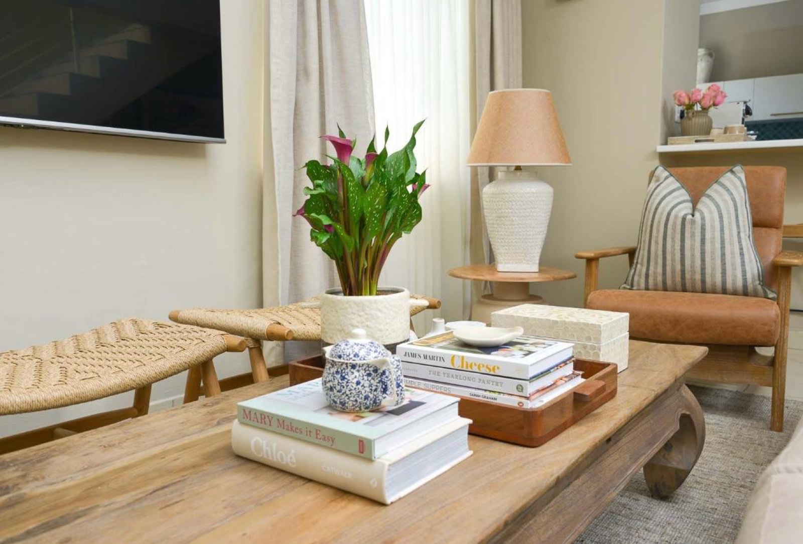 The sitting room coffee table, with books, ceramics and a leather chair